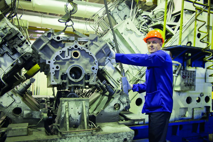 С помощью кран-балки Сергей Кондратьев бережно переносит обработанный блок цилиндров на специальный стол для измерений