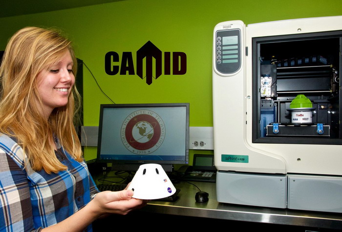 Студентка Флоридского технологического института Грейс Питерс-Шульц держит напечатанную 3D-модель космического аппарата НАСА Orion